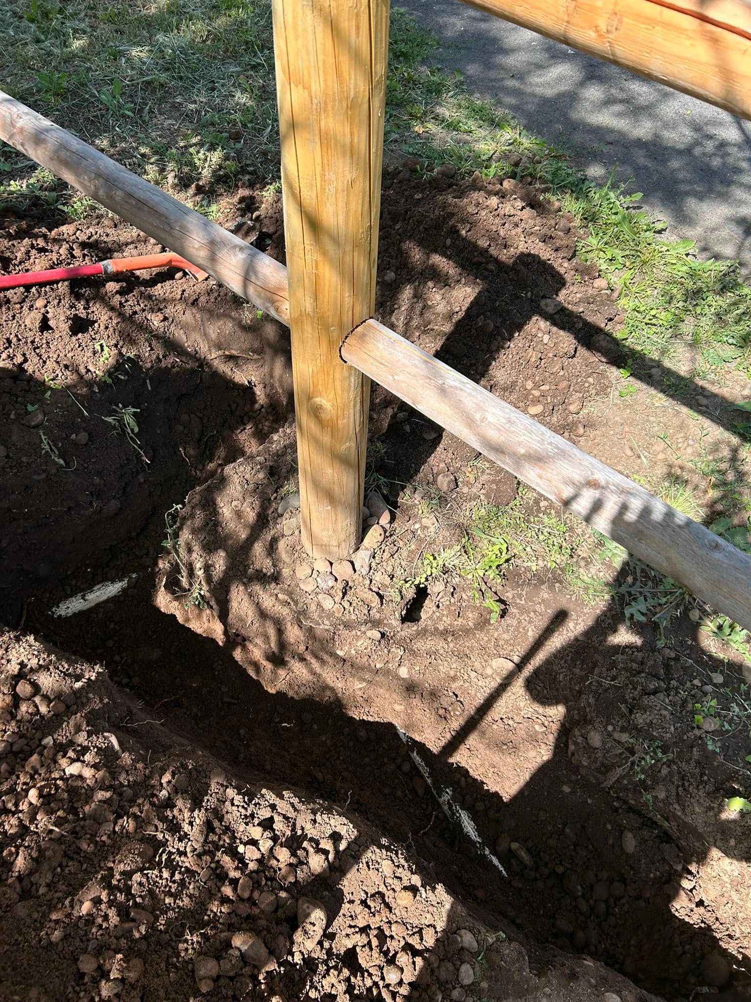 A wooden post is sitting in the middle of a hole in the ground.