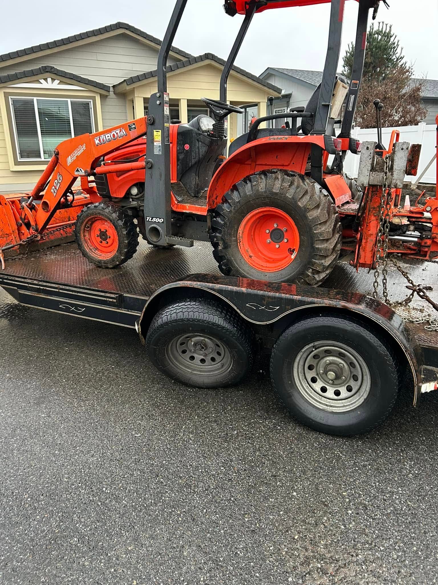 A tractor is sitting on top of a trailer.