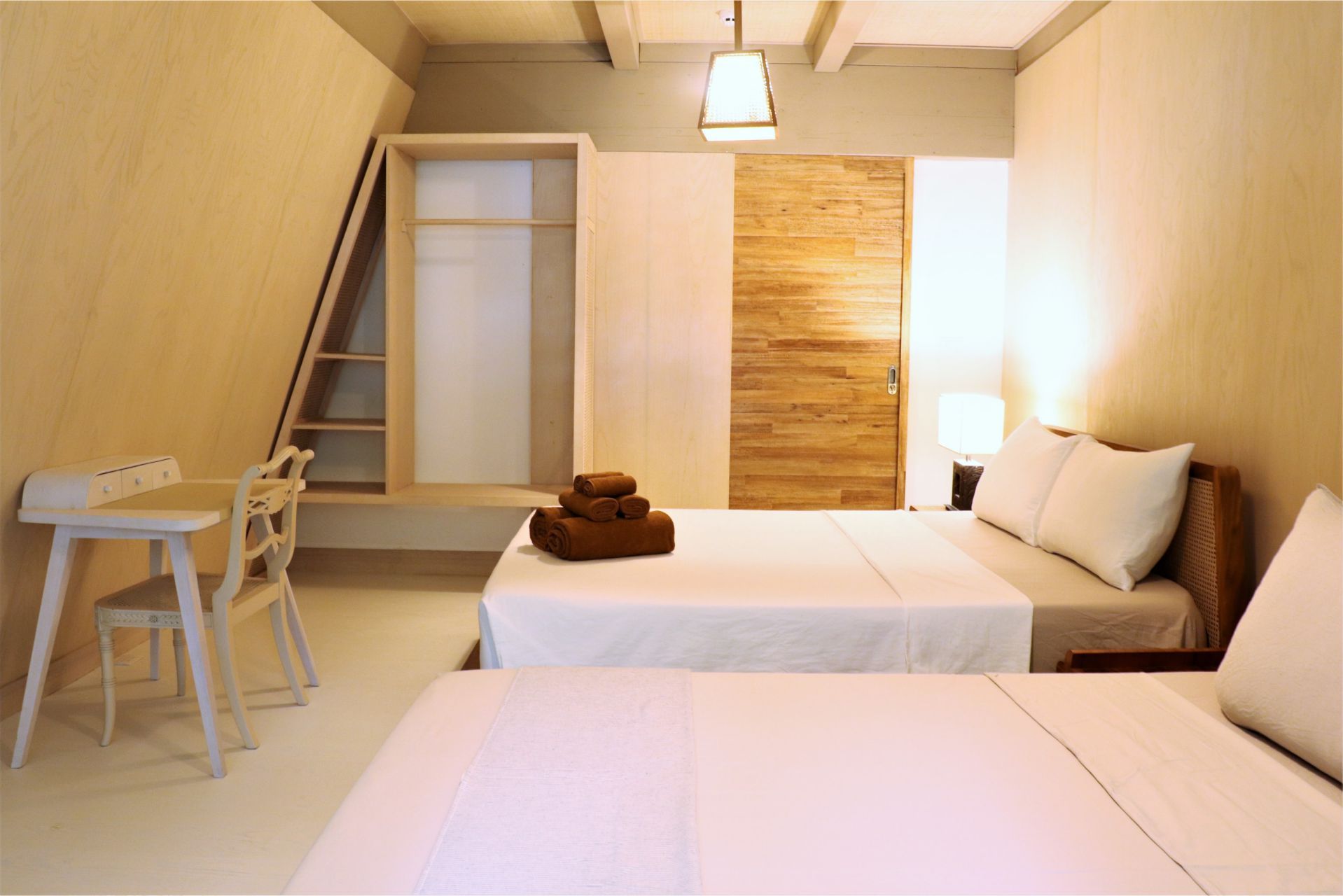 Hotel room bed and writing desk of Asmara Urban Resort & Lifestyle Village Cebu