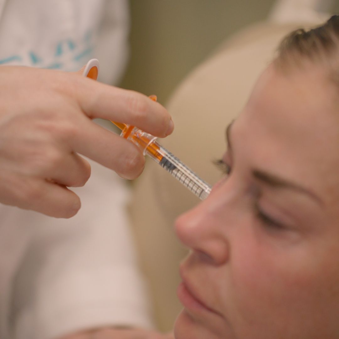 A woman is getting an injection in her nose