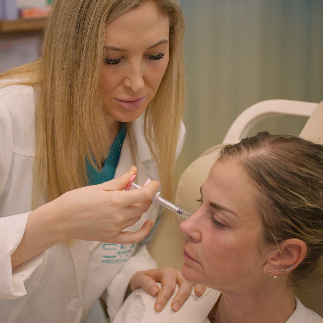 A woman is getting an injection in her face by a doctor