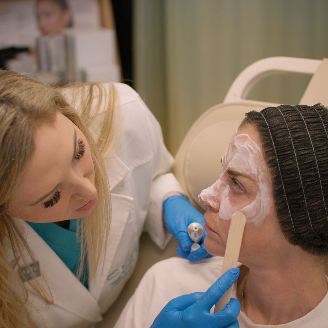 A woman with a bandage on her face is being examined by a doctor.