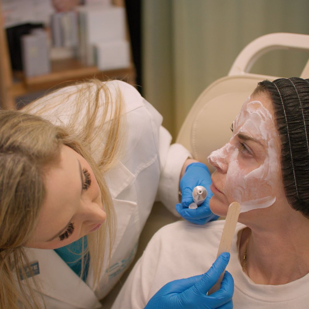A woman with a mask on her face is being examined by a doctor