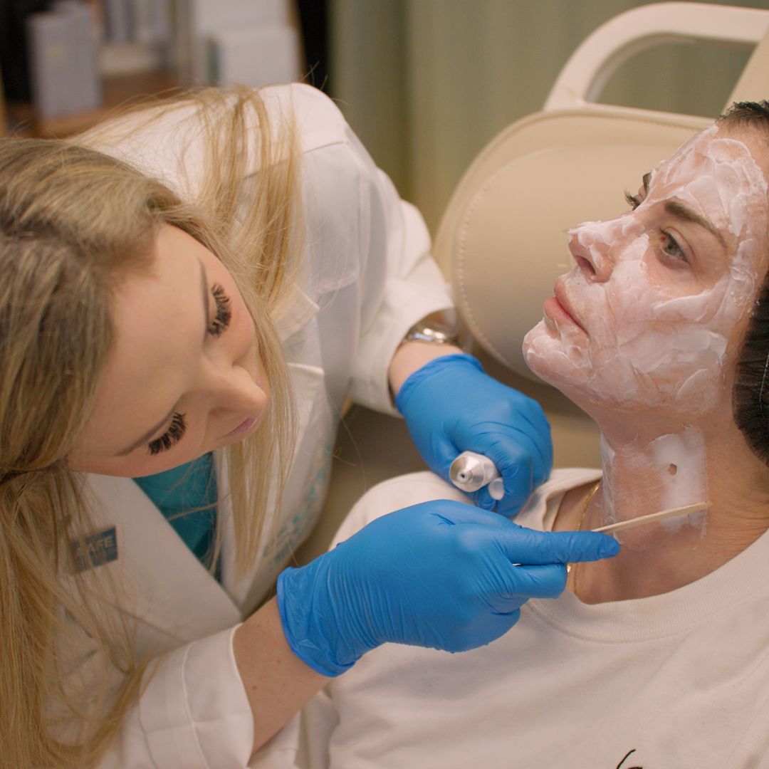 A woman is getting a facial treatment from a doctor.