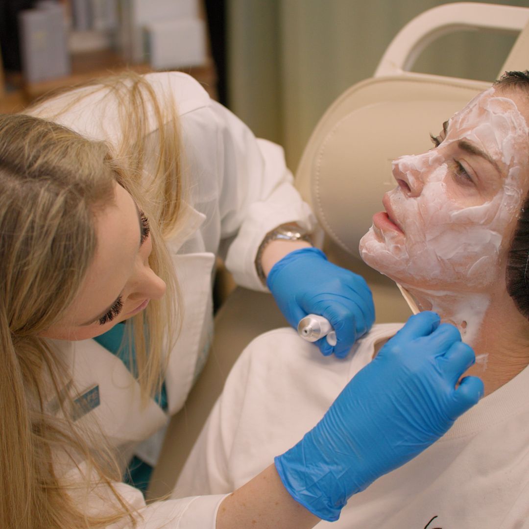 A woman is getting a facial treatment from a doctor.
