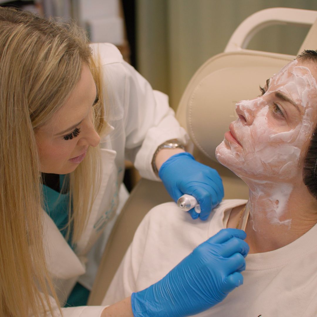 A woman is getting a facial treatment from a doctor.