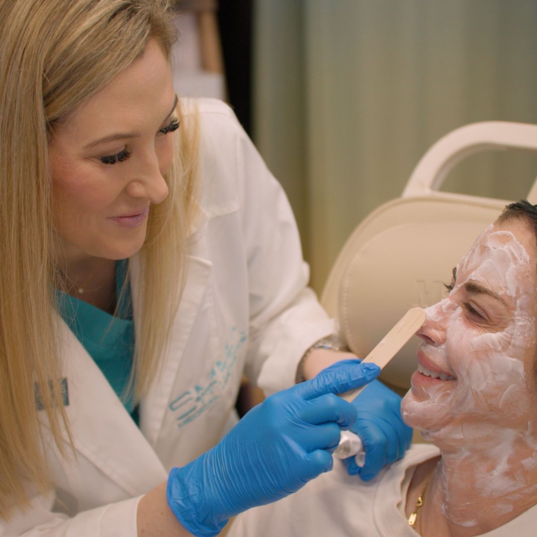 A woman is getting a facial treatment from a doctor.