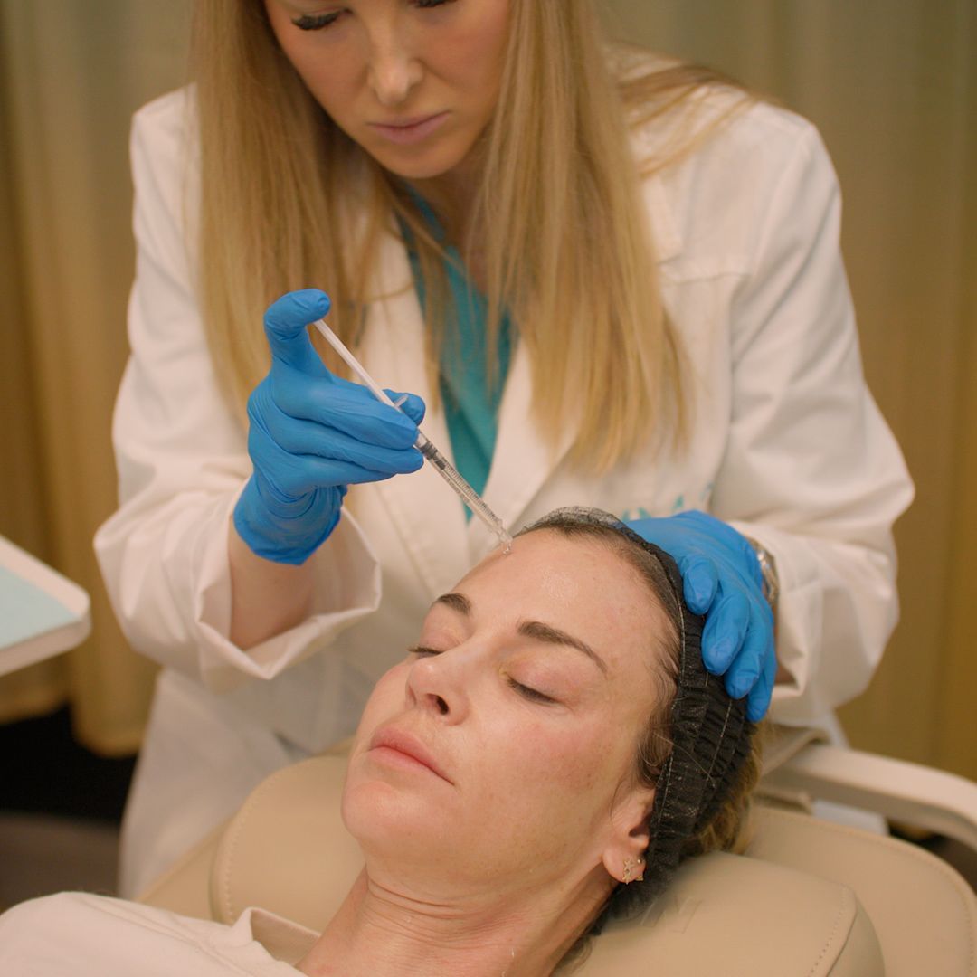 A woman is getting an injection in her face by a doctor.