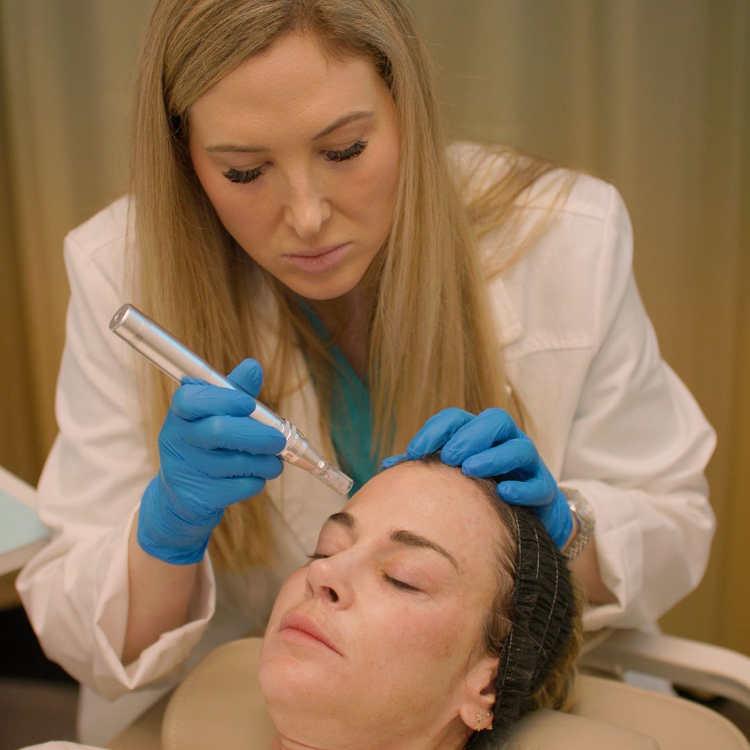 A woman is getting a facial treatment from a doctor.
