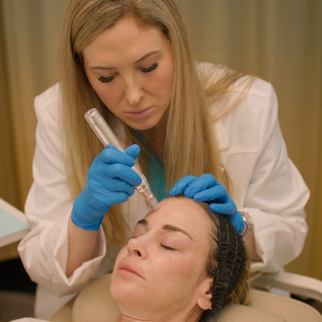 A woman is getting a facial treatment from a doctor.