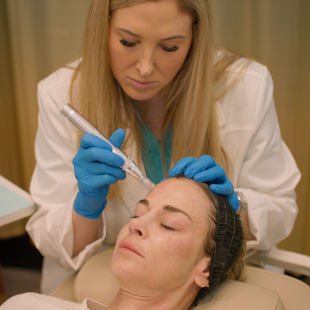 A woman is getting a treatment on her face by a doctor.