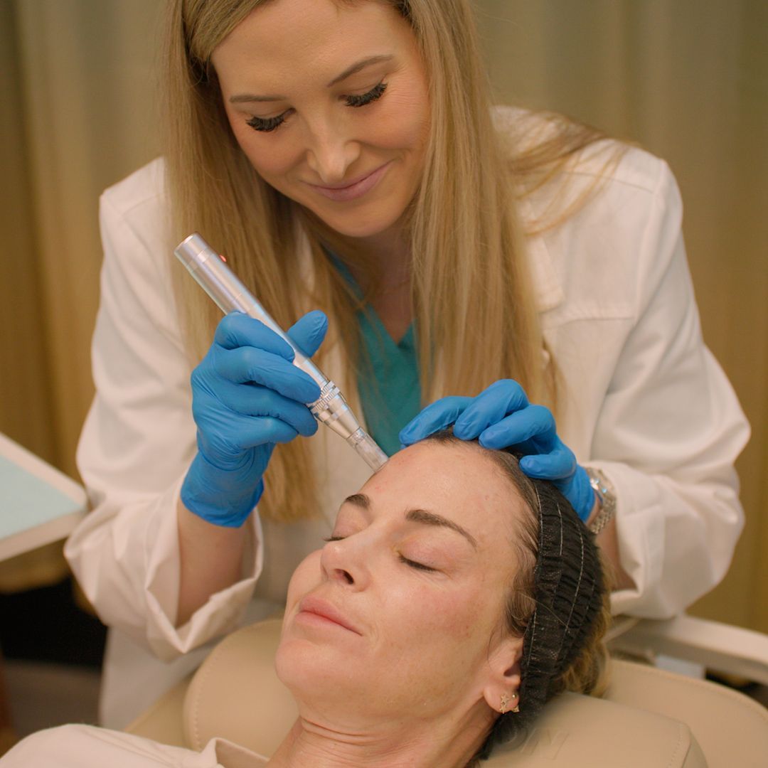 A woman is getting a facial treatment from a doctor.