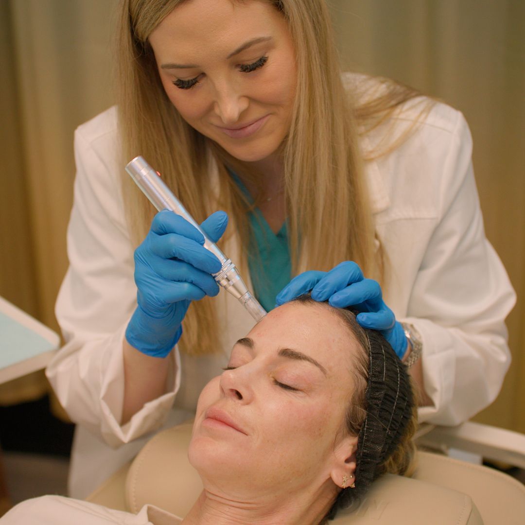 A woman is getting a treatment on her face by a doctor.