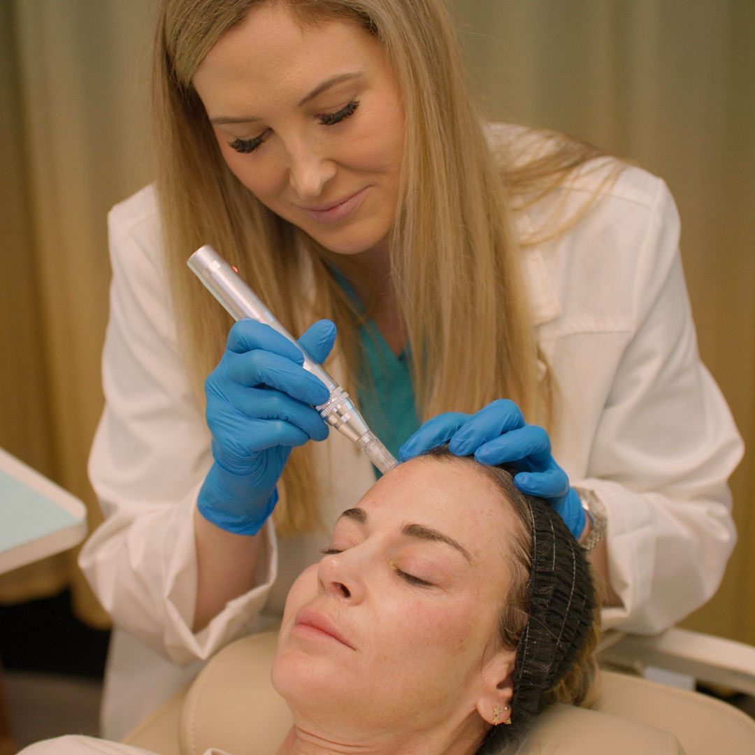 A woman is getting a facial treatment from a doctor.