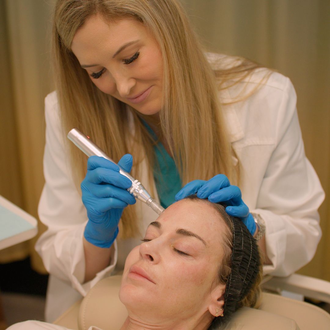 A woman is getting a treatment on her face by a doctor.
