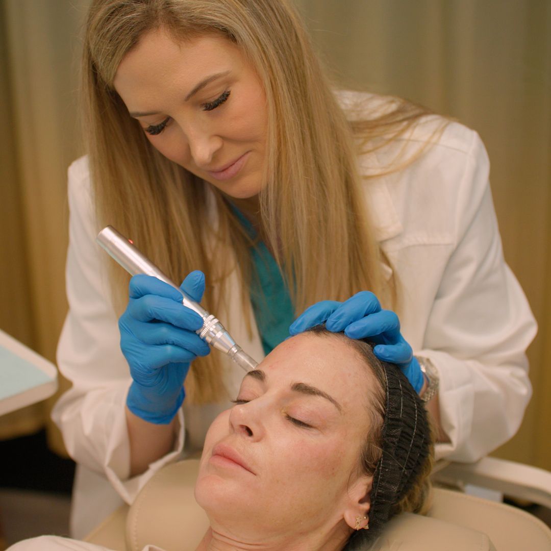 A woman is getting a tattoo on her eyebrows by a doctor.