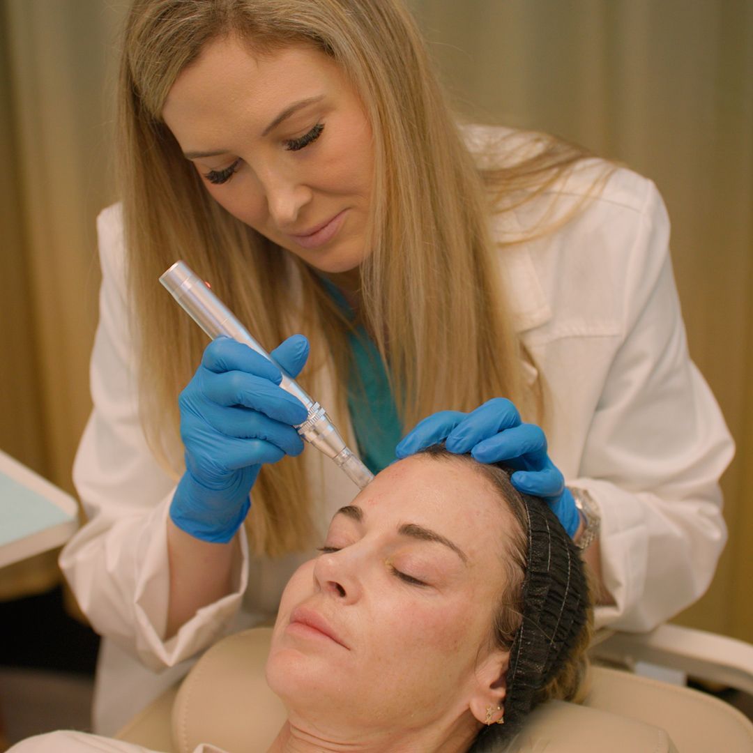 A woman is getting a facial treatment from a doctor.