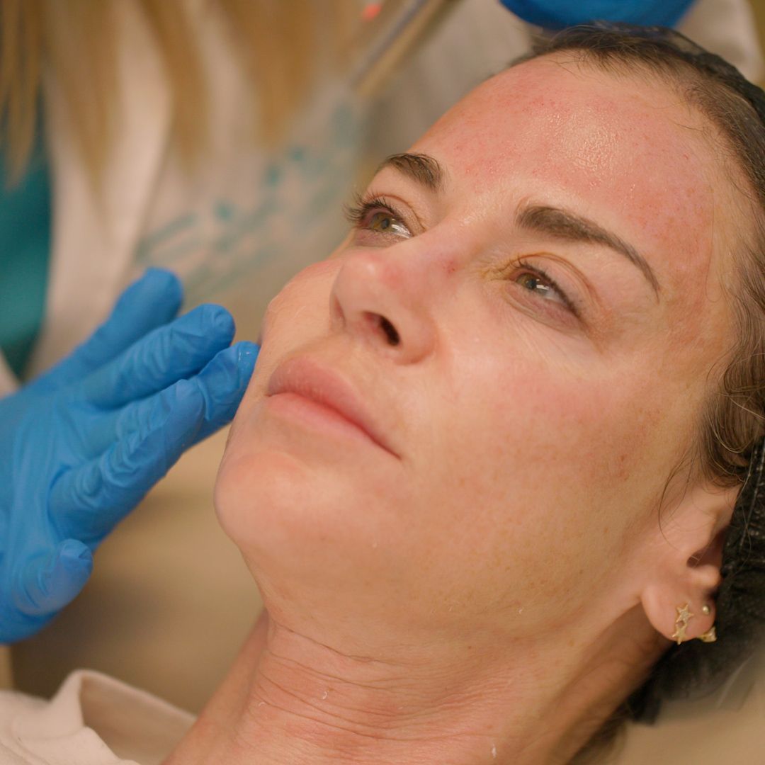 A woman is getting a facial treatment from a doctor.