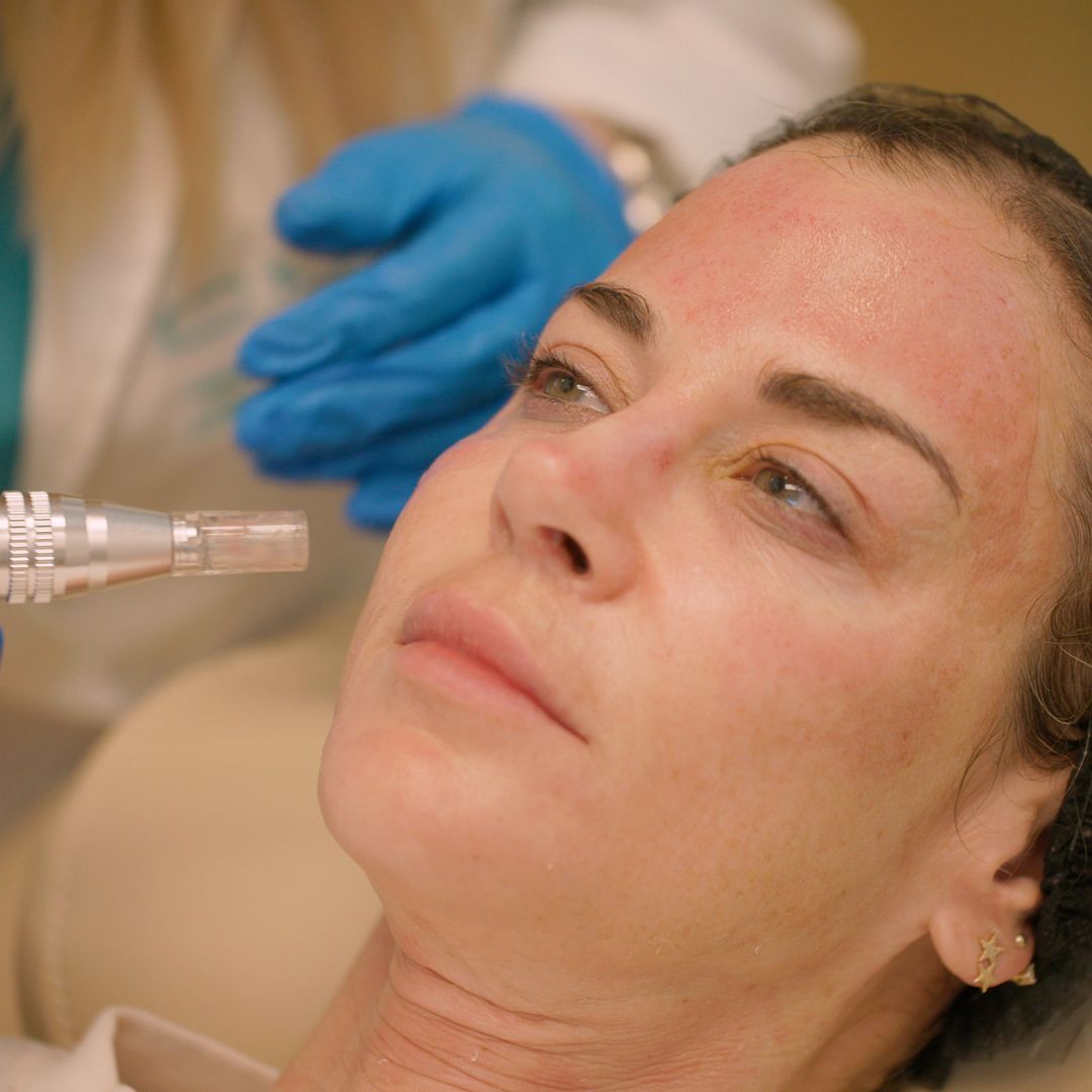 A woman is getting a facial treatment from a doctor.