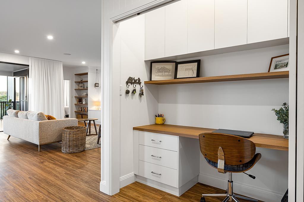 a home office with a wooden desk and chair in a living room .
