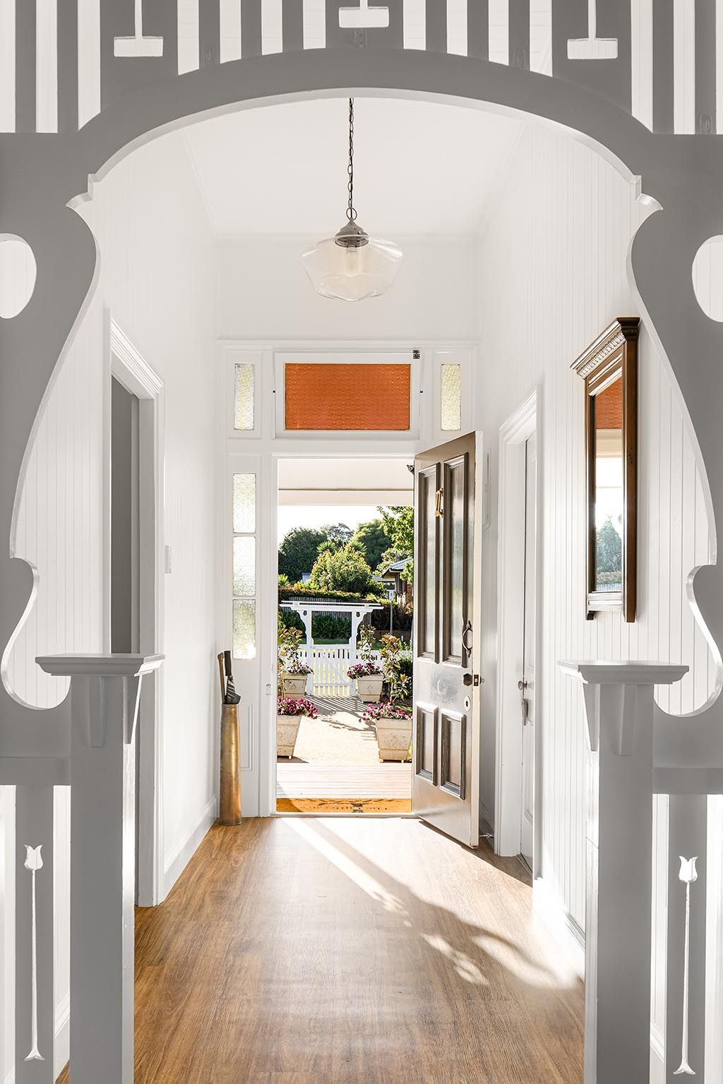 a hallway with a wooden floor and a doorway leading to a porch .
