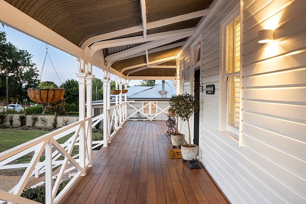 a white house with a large porch and a ceiling fan