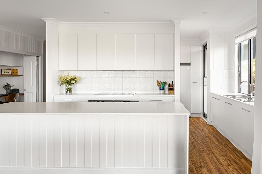 a kitchen with white cabinets and a wooden floor .