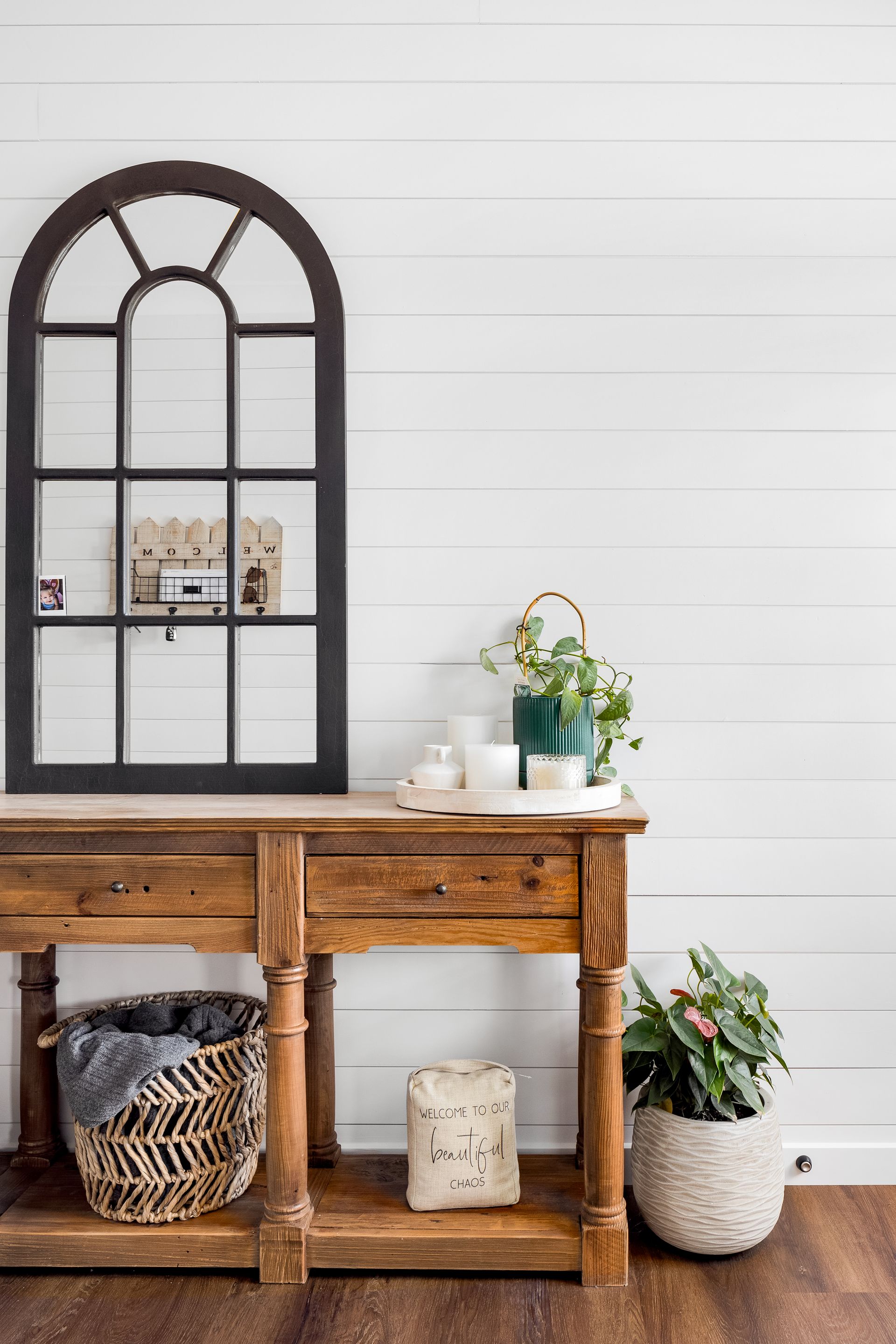 a wooden table with a mirror on the wall next to it .