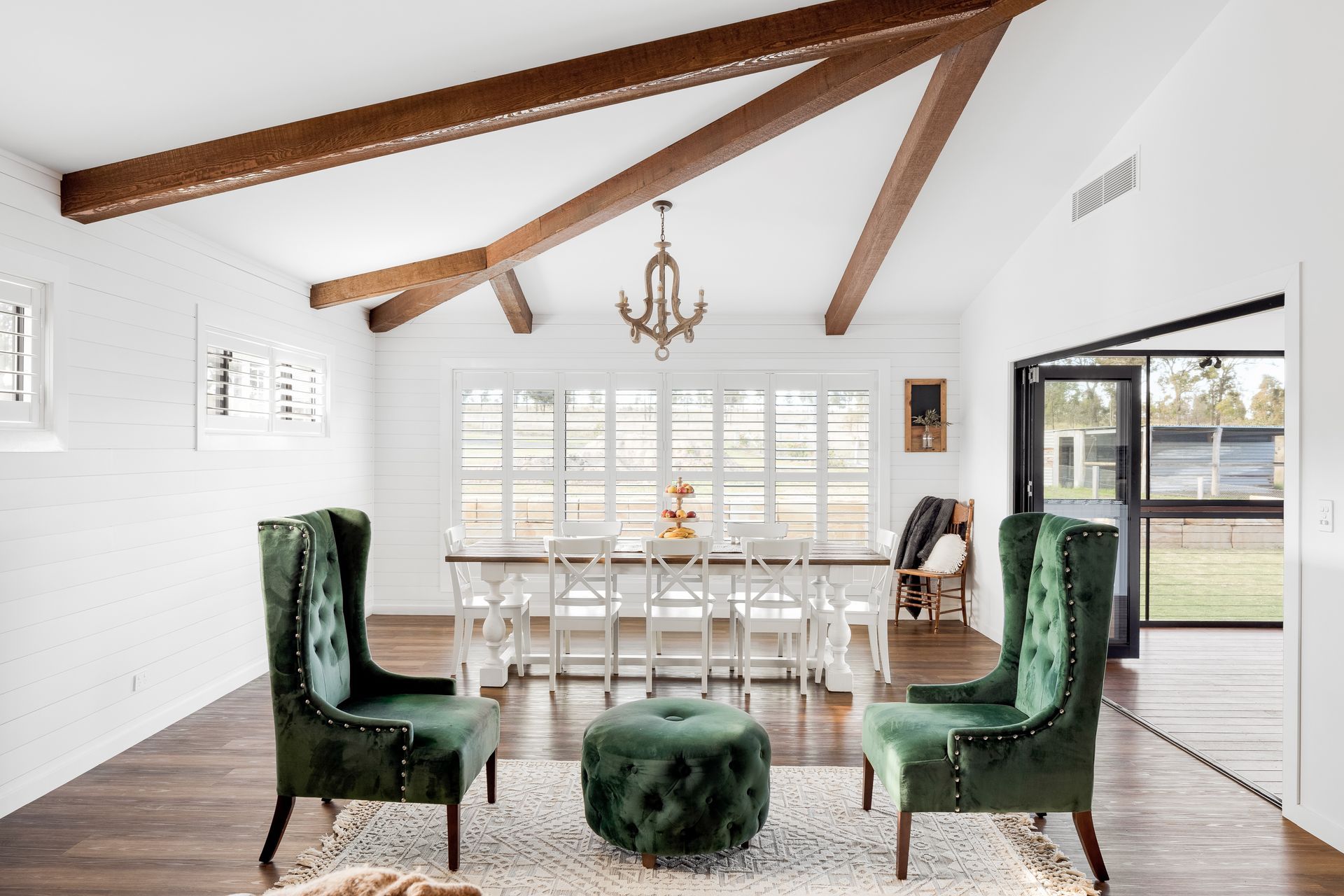 a living room with green chairs and a green ottoman .