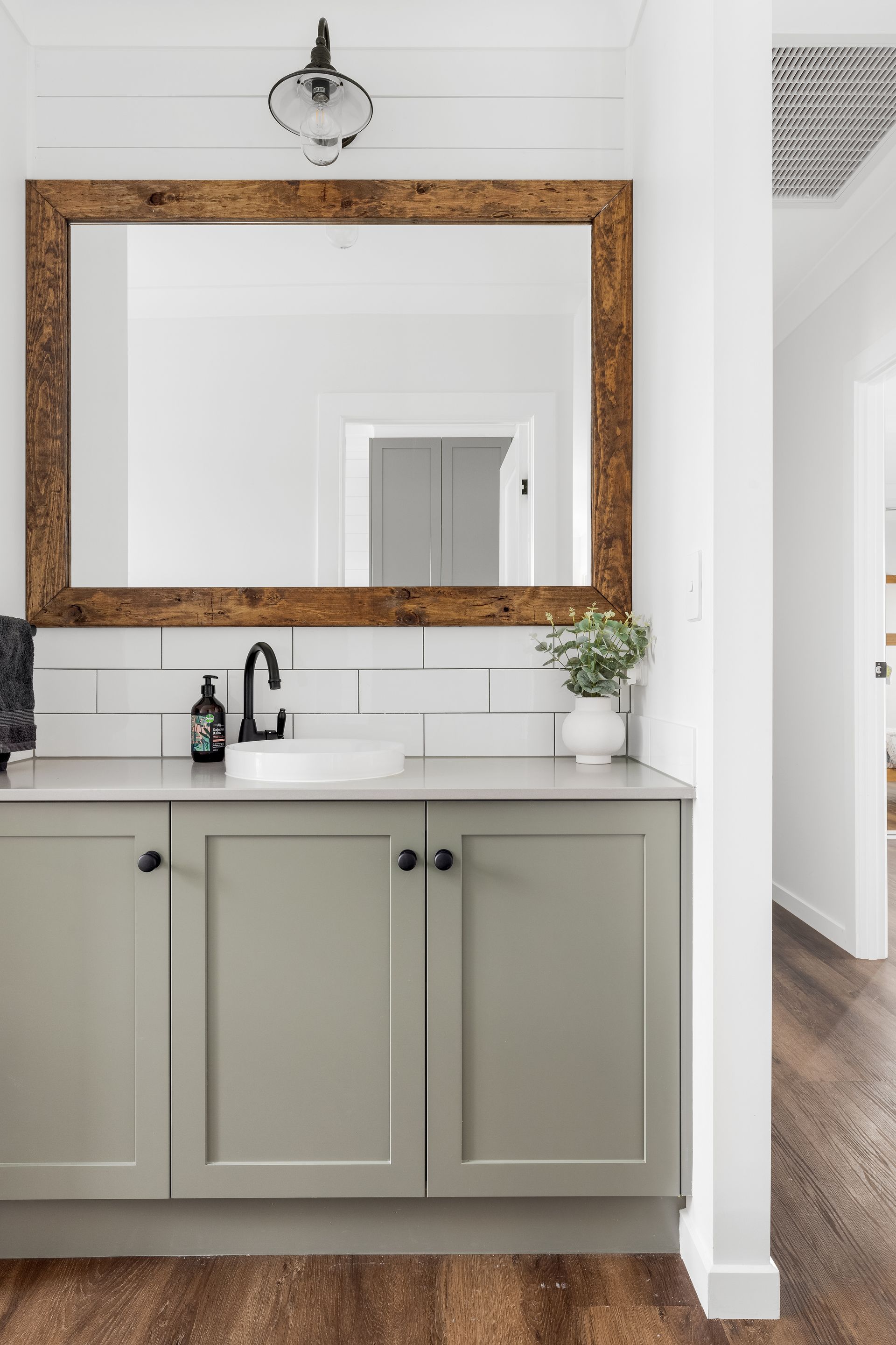 a bathroom with a sink , mirror and cabinets .