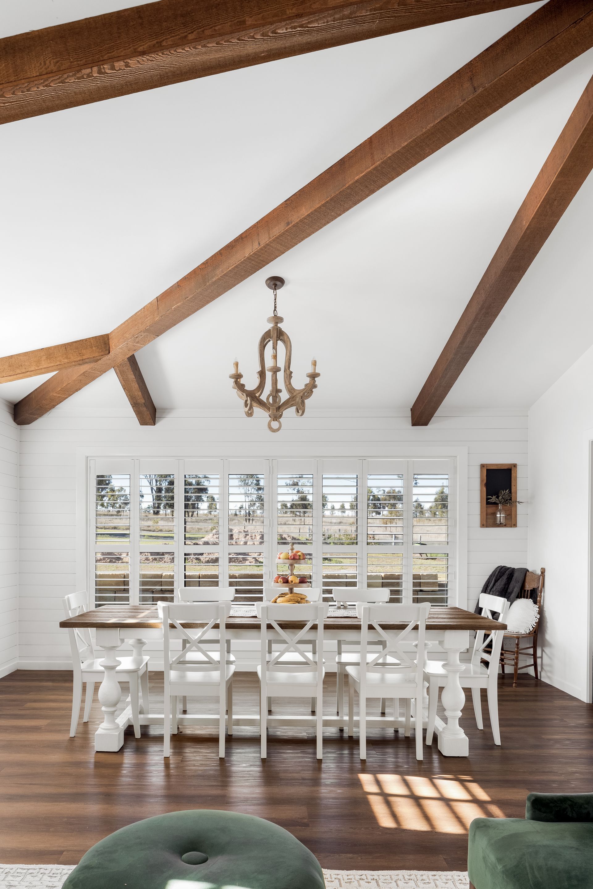 a dining room with a long table and chairs and a chandelier hanging from the ceiling .