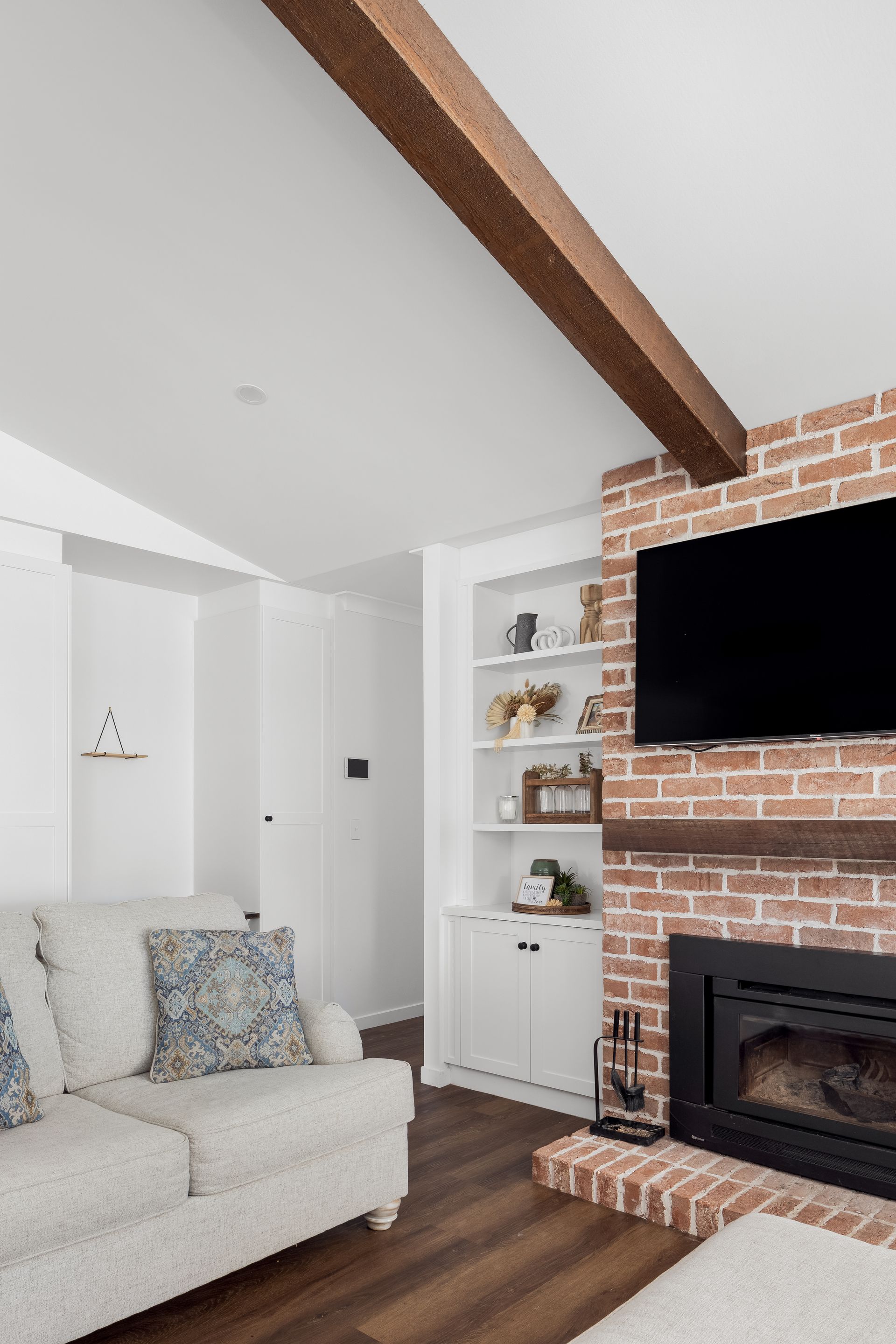 a living room with a brick fireplace and a flat screen tv