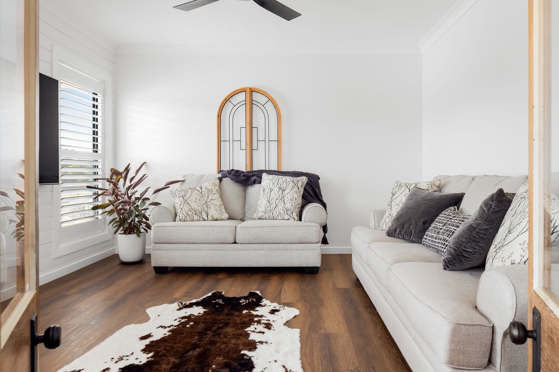 a living room with a couch , rug , and ceiling fan .