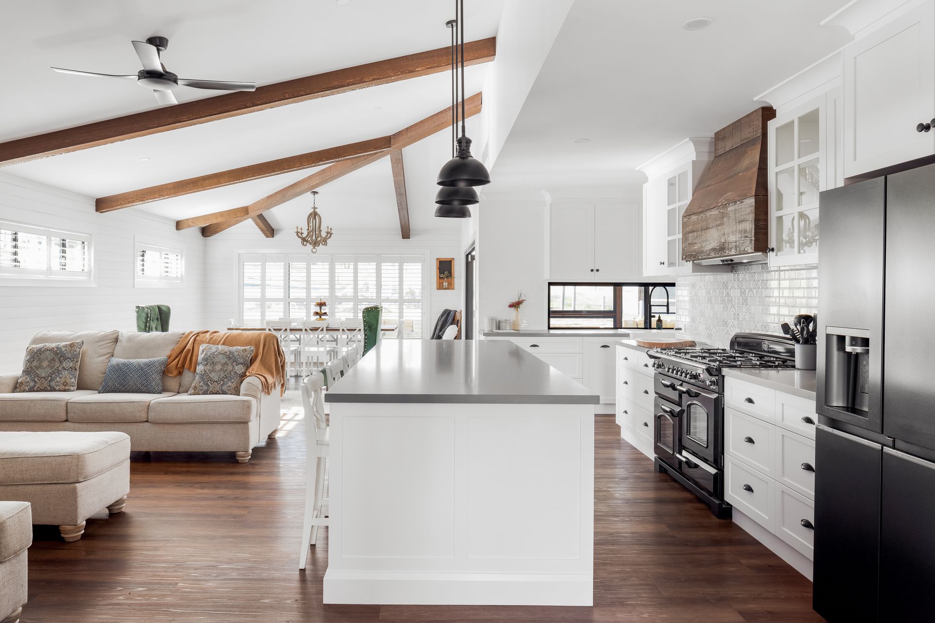 a kitchen with white cabinets and stainless steel appliances and a large island in the middle of the room .