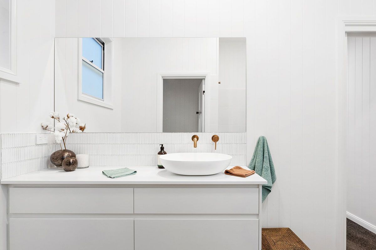 a bathroom with a sink , mirror and window .