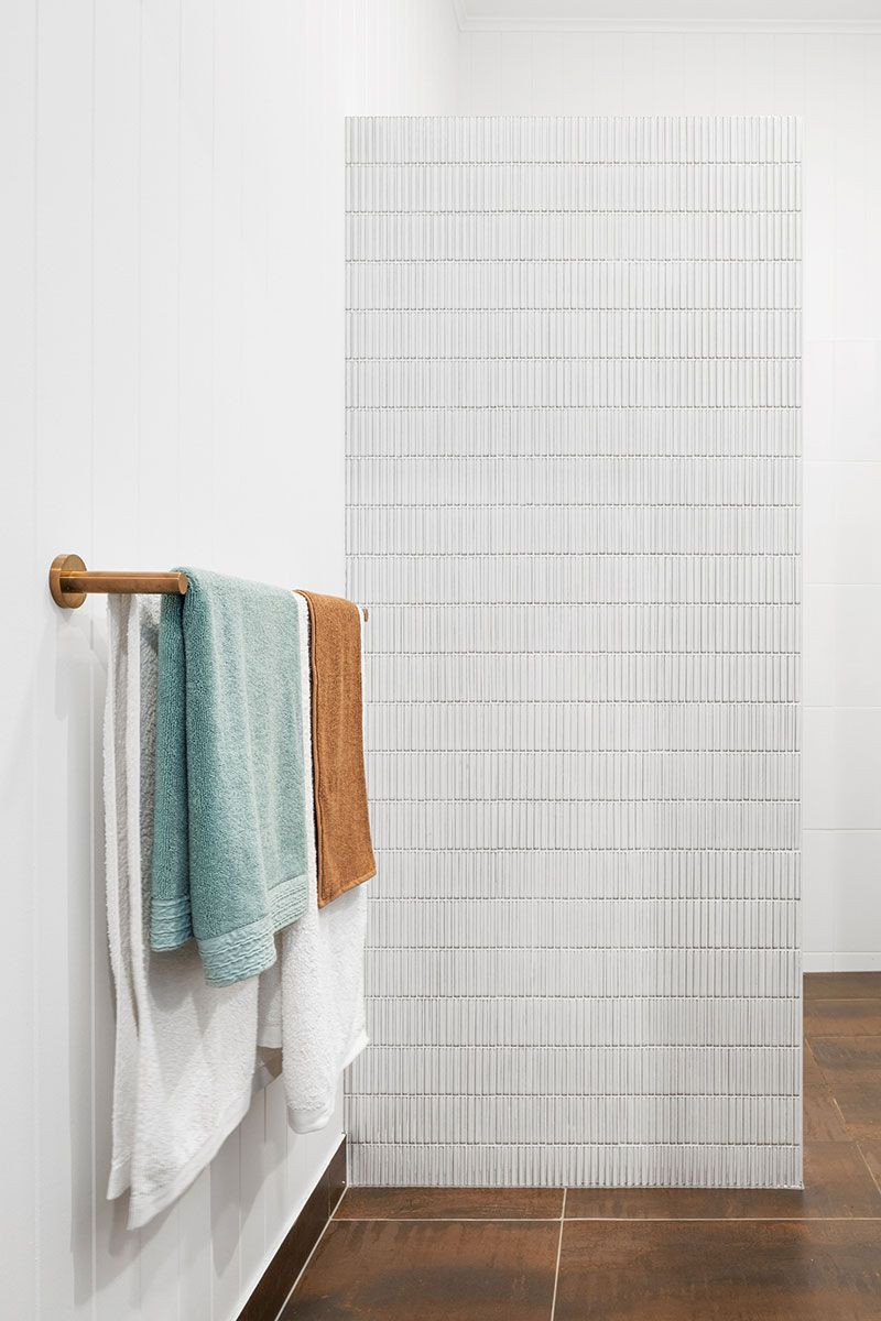 a bathroom with a towel rack and towels hanging on the wall .