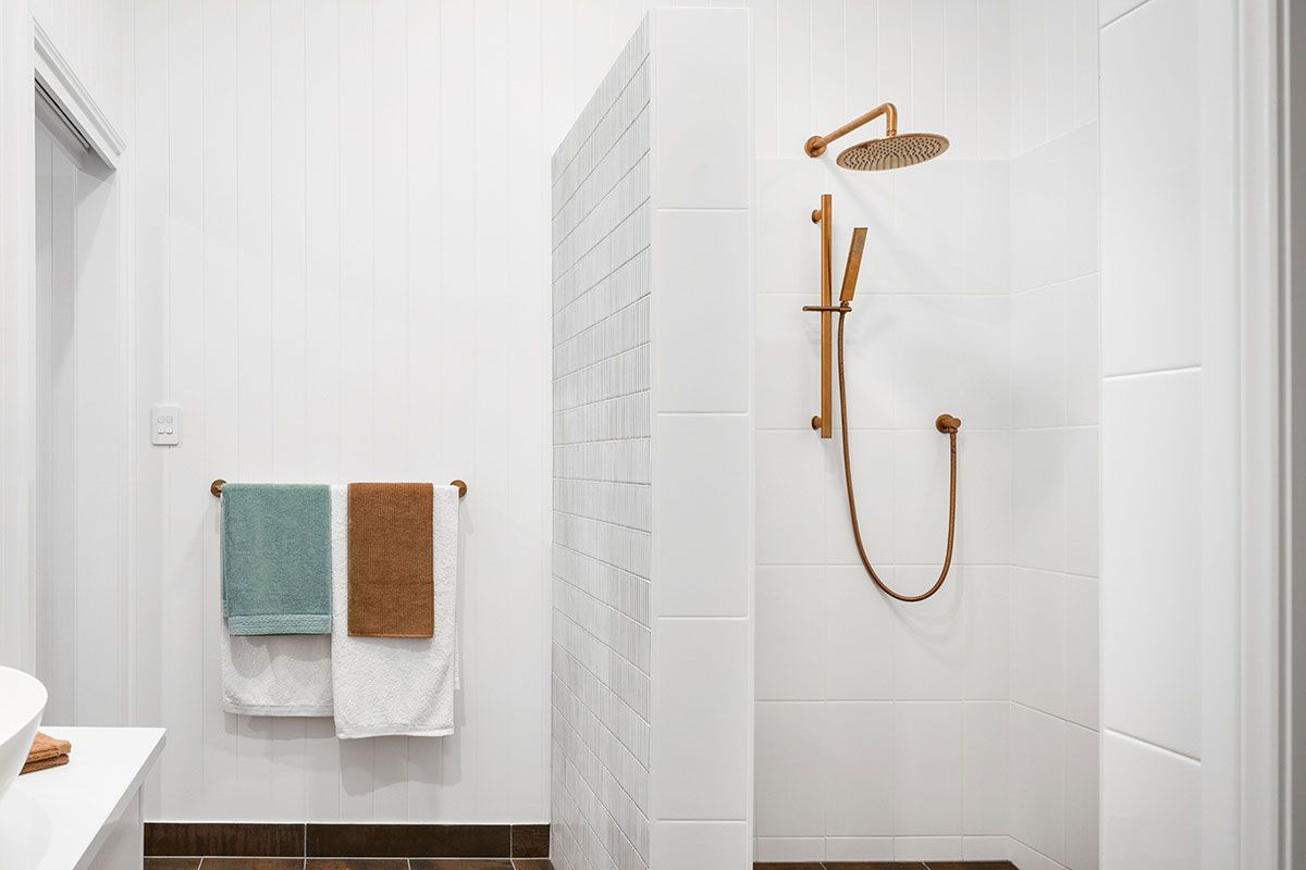 a bathroom with a walk in shower and two towels hanging on the wall .