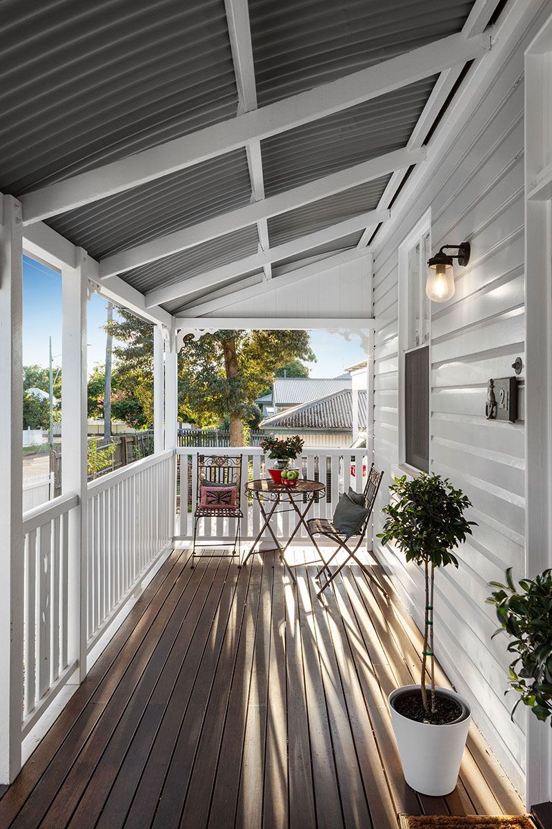 there is a porch with a table and chairs on it .