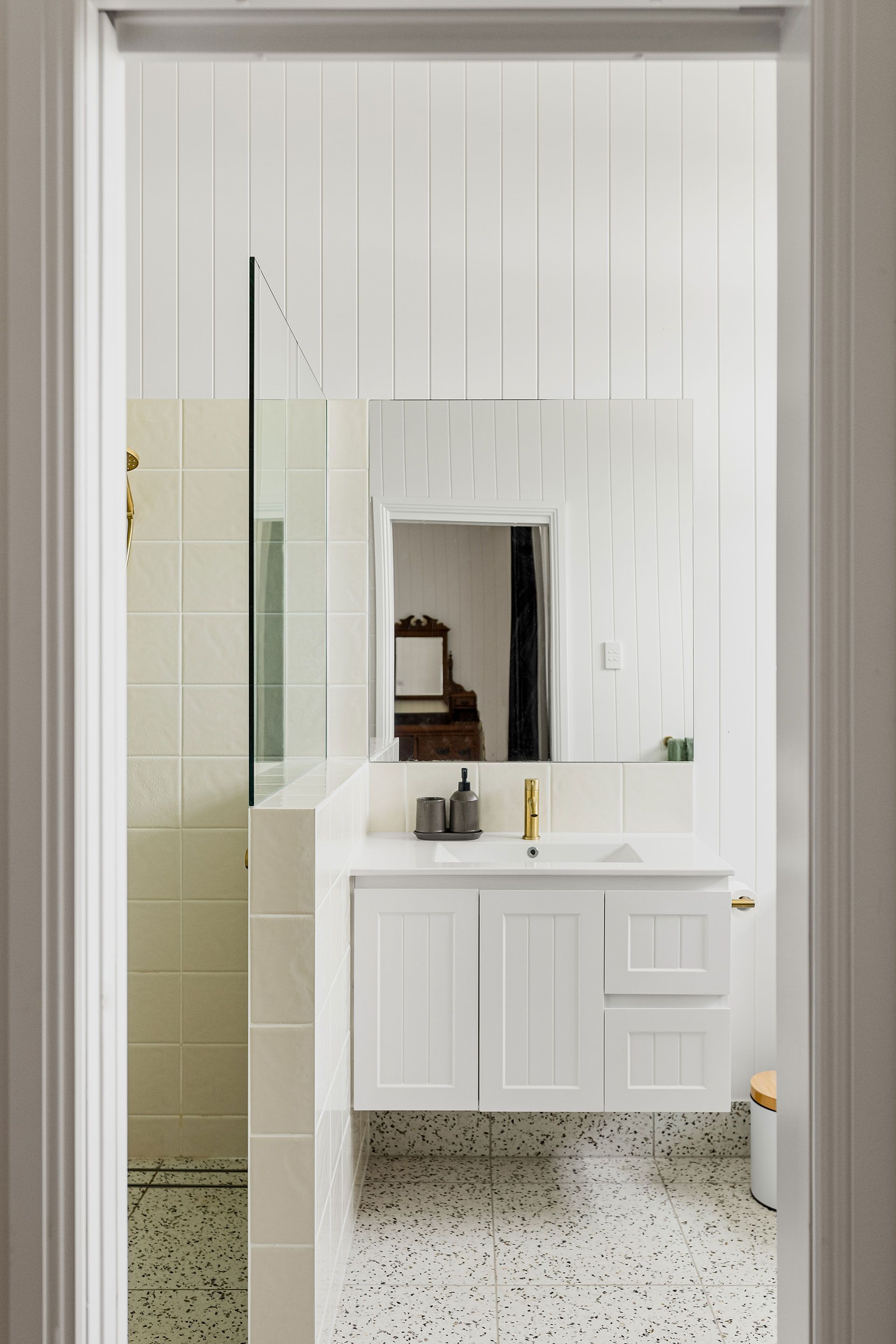 A bathroom with a sink , mirror and walk in shower.