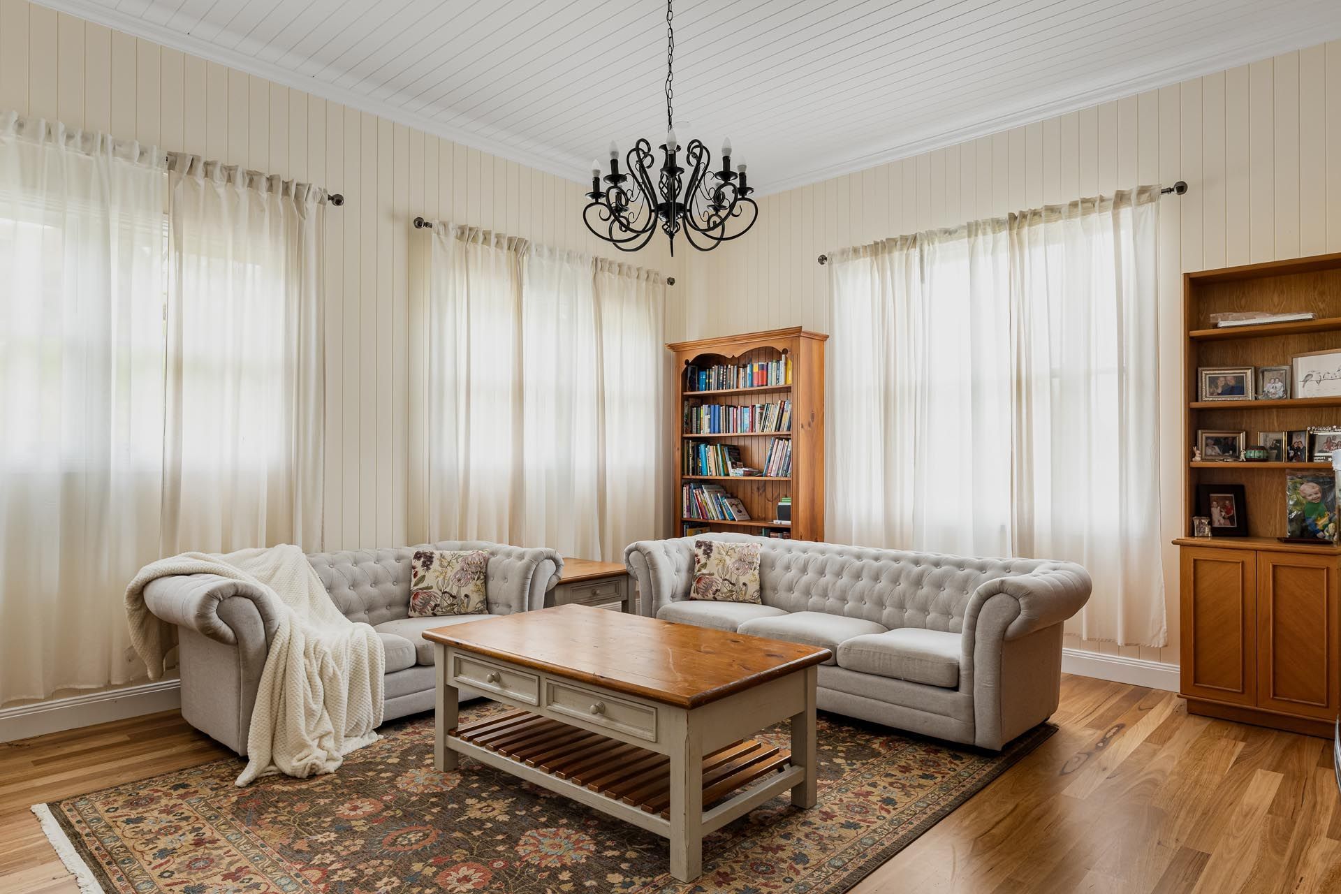 A living room with two couches , a coffee table , and a bookshelf.