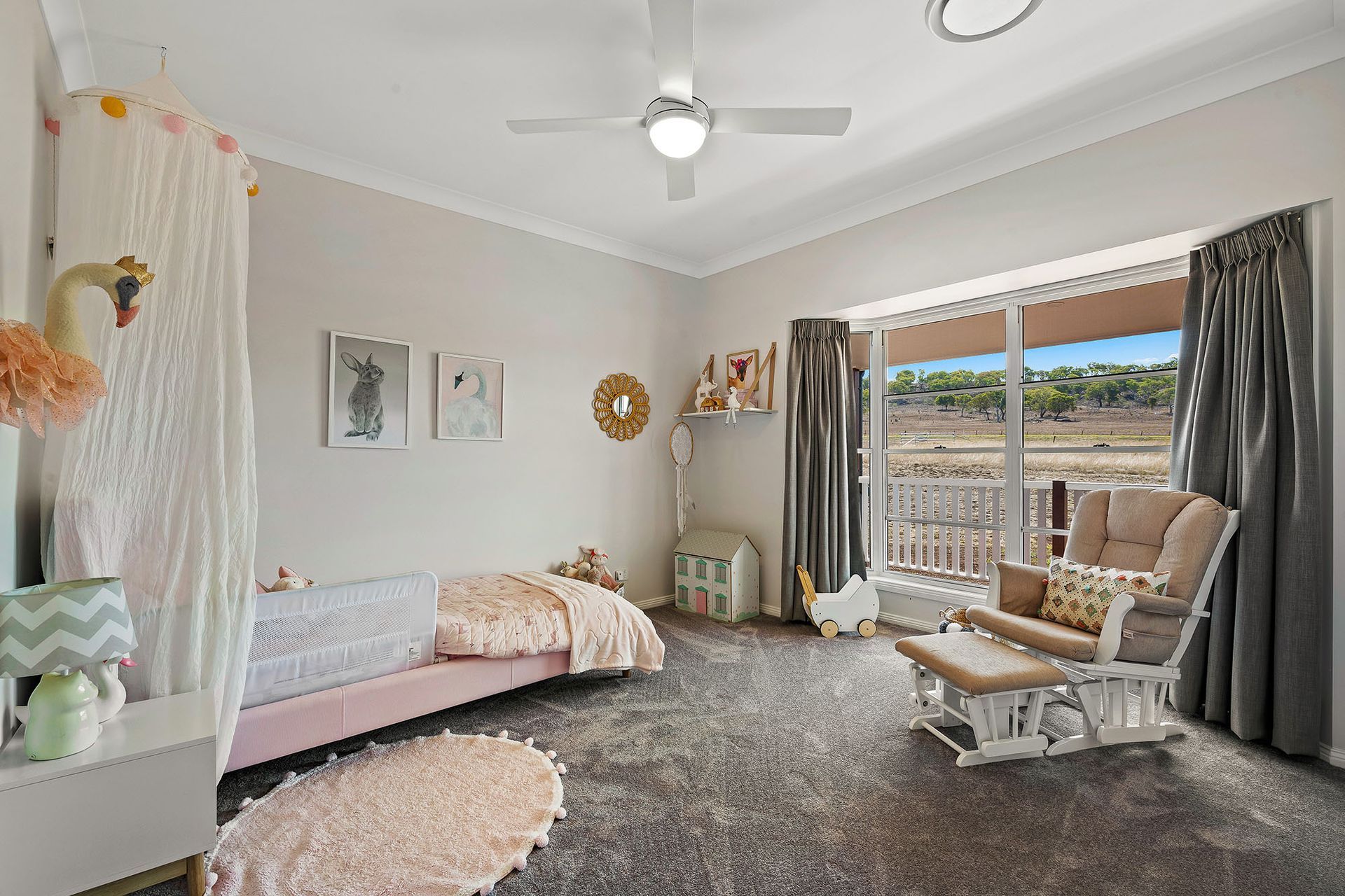 a bedroom with a bed , rocking chair , and ceiling fan .