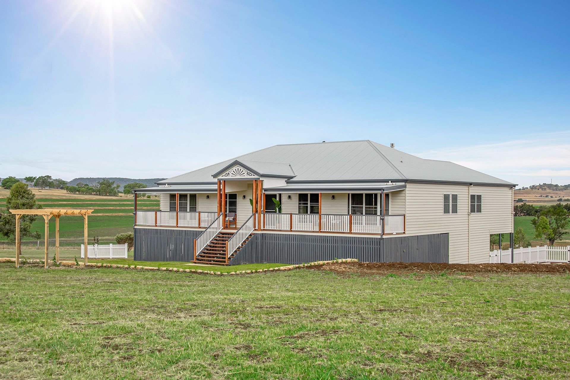 a large house is sitting in the middle of a grassy field .