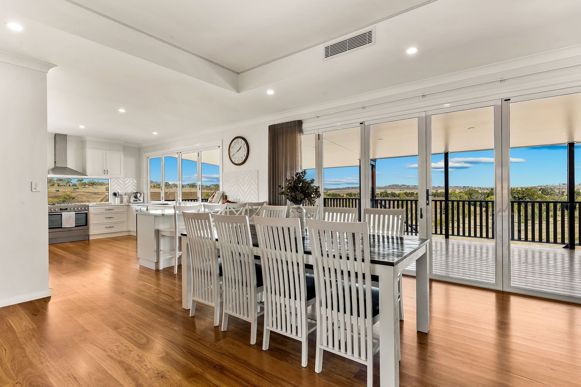 a large dining room with a table and chairs and a balcony .