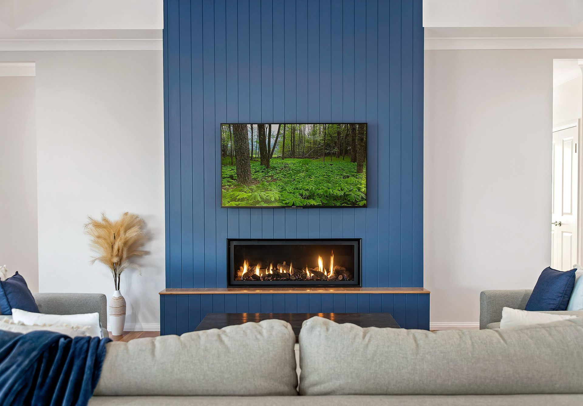 a living room with a fireplace and a flat screen tv on the wall .