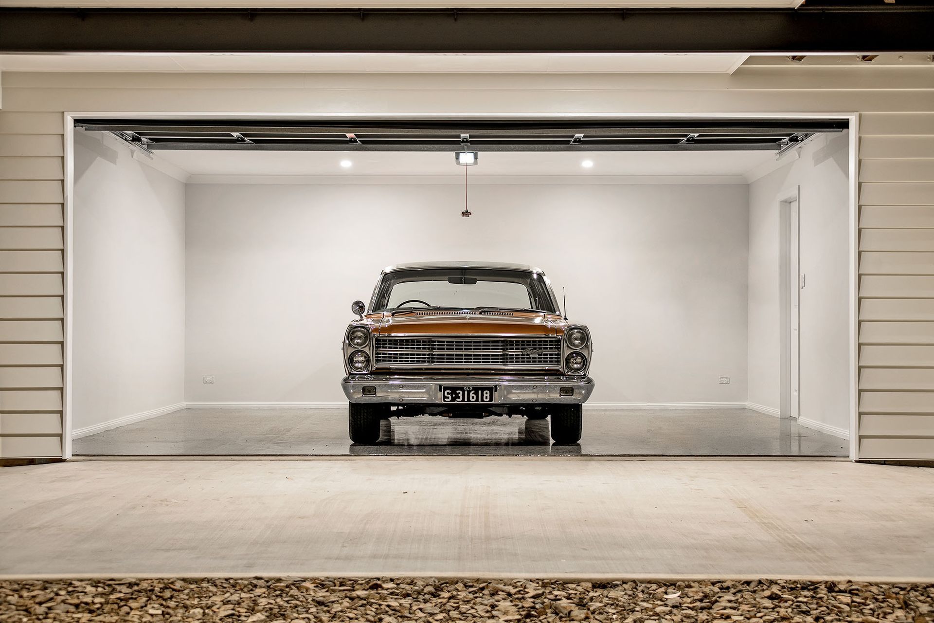 a car is parked in a garage with the door open .