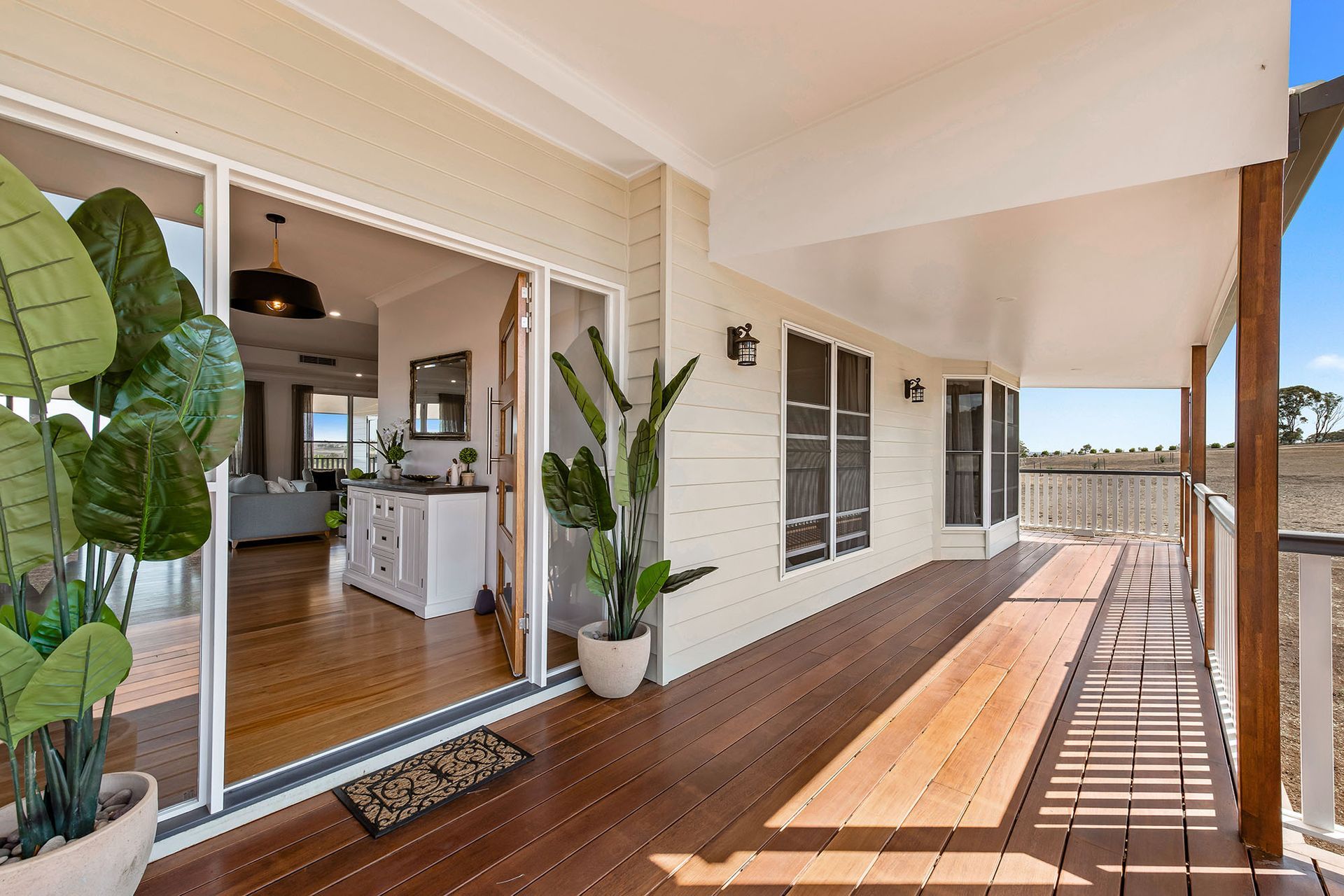 a large porch with sliding glass doors leading to a living room and kitchen .