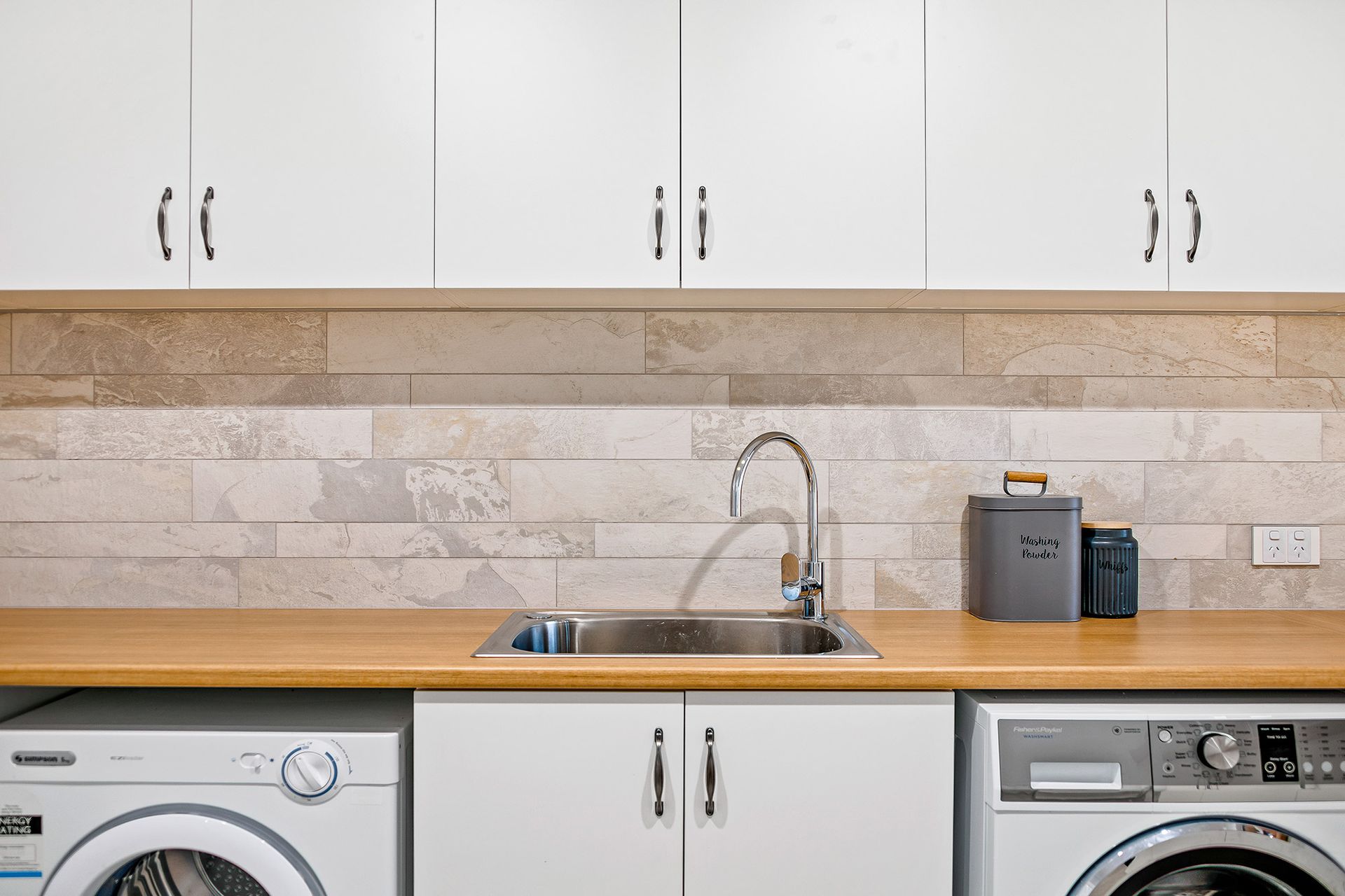 a laundry room with a sink , washer and dryer .