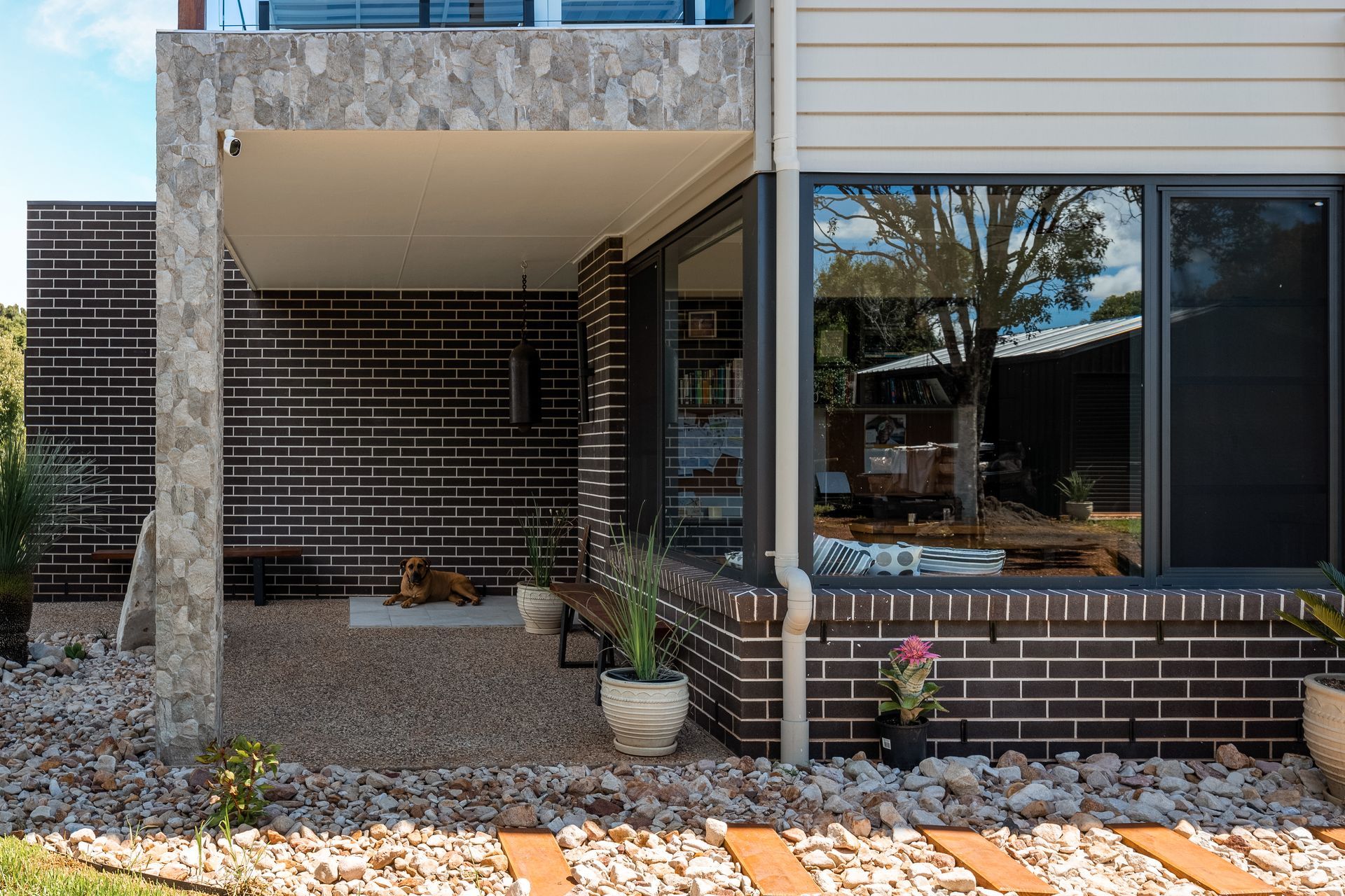 the front of a house with a brick wall and a large window .