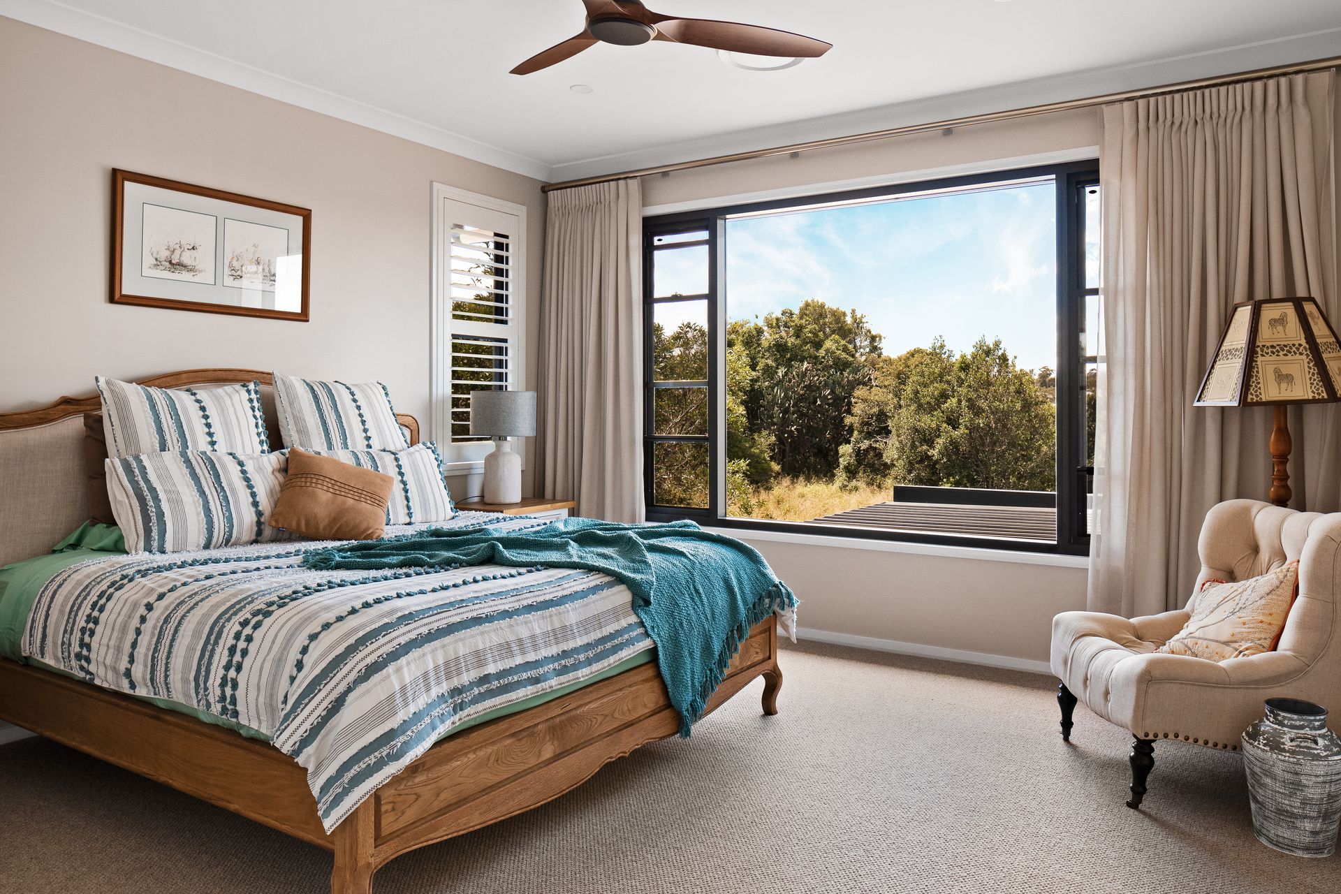 a bedroom with a bed , chair , lamp and ceiling fan .