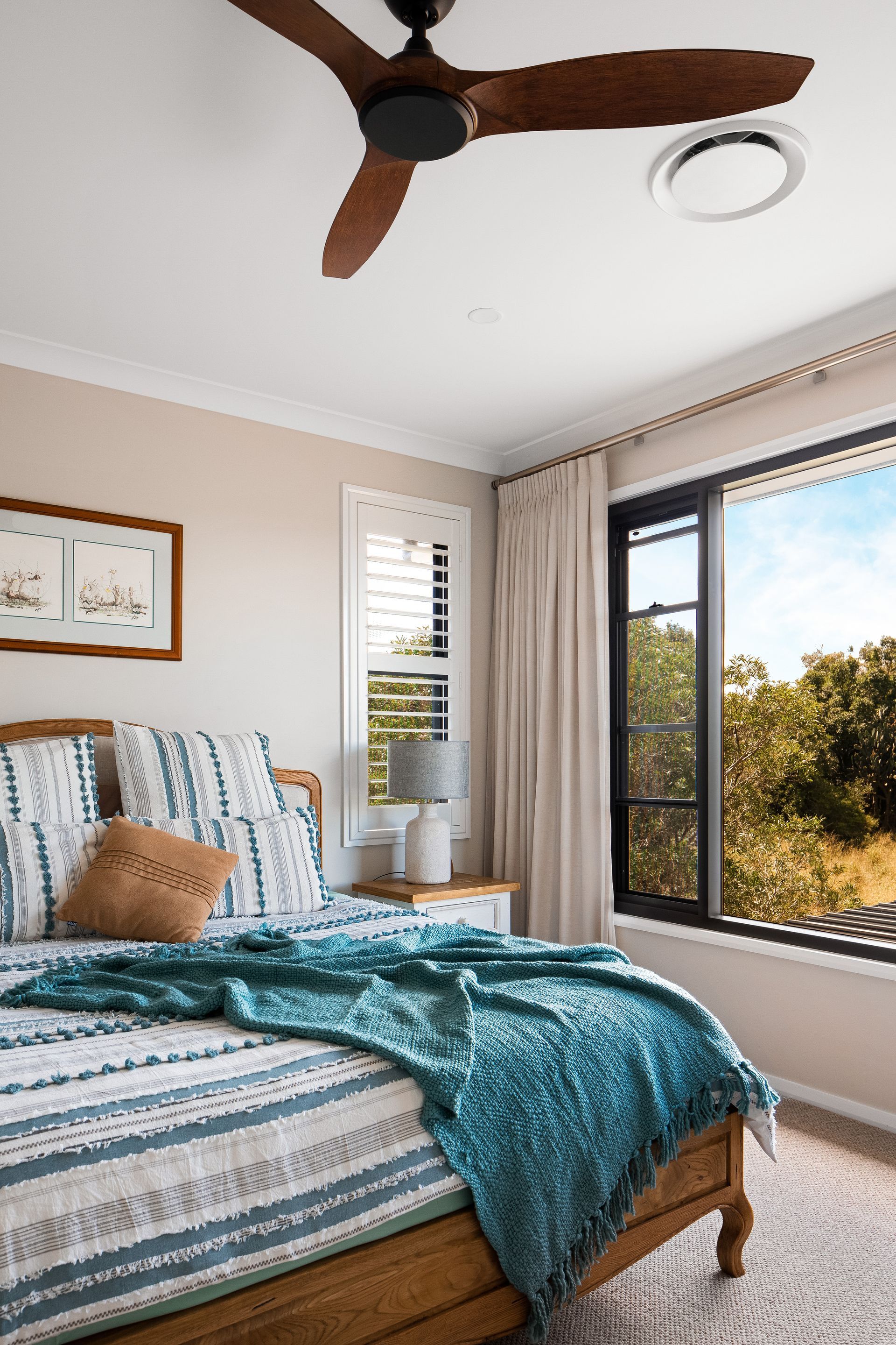 a bedroom with a bed , ceiling fan and window .